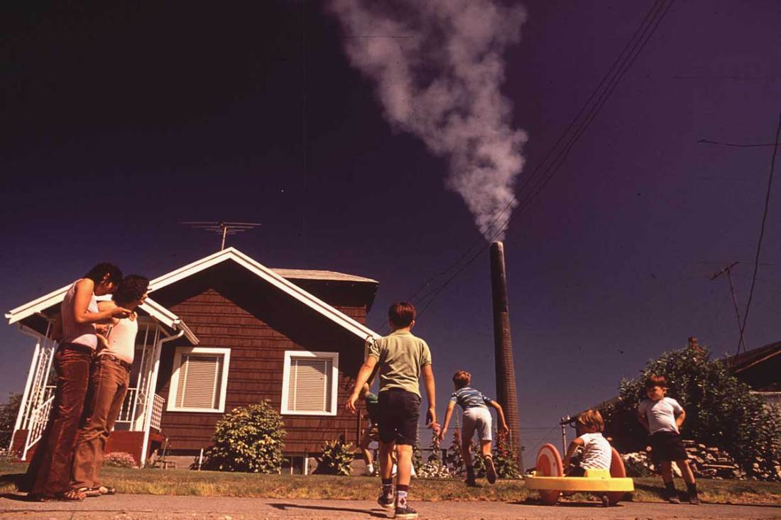 Children play in yard of Ruston home, while Tacoma smelter stack showers area with arsenic and lead residue, August 1972
